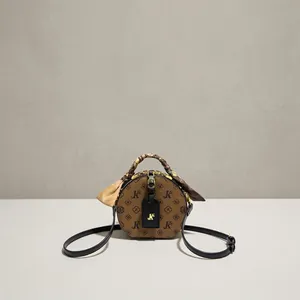 Detailaufnahme einer Vintage-Monogramm-Rundtasche mit dekorativem Seidenschal für Damen