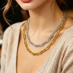 Detail shot of minimalist gold and silver chain link necklaces on a model's neck