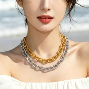 Detailed shot of layered gold and silver chunky curb chain necklaces on an Asian model.
