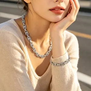 Elegant silver-toned H-link chain necklace and bracelet jewelry set on female model