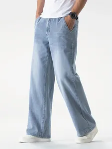 Jeans in denim azzurro da uomo con gamba larga e vestibilità comoda in studio