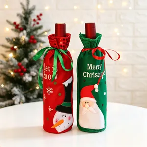 Gros plan de housses de bouteille de vin de Noël rouges et vertes avec motifs festifs.