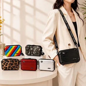 Stylish hardshell mini suitcase crossbody bag for women featuring a logo webbing strap