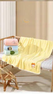 Close-up of soft coral fleece baby blanket featuring cute cartoon animal embroidery