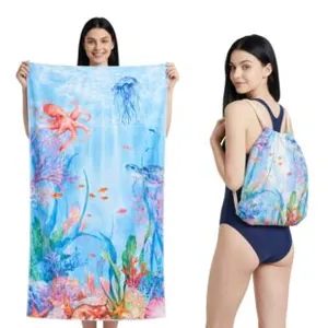 Large microfiber beach towel featuring vibrant ocean prints used as a handy drawstring bag