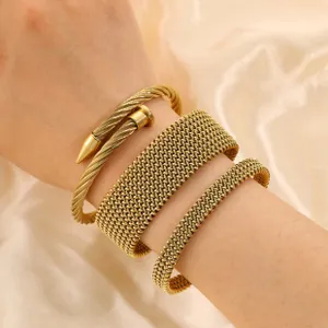 Close-up detail of three-piece golden stainless steel twisted nail and mesh bracelet set