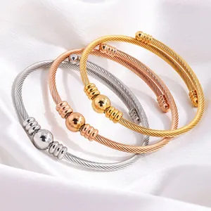 Detail view of three elegant braided titanium steel bangles in gold, silver, and rose gold.