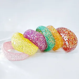 Set of colorful glitter resin bangles with shimmering fragments in a bold chunky style