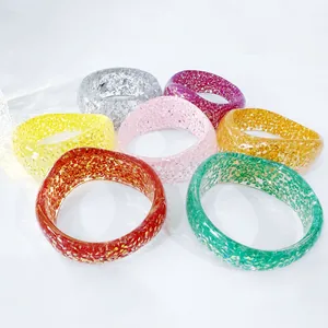 Detailed close-up showing seven colorful chunky resin bangles with glitter inlays.