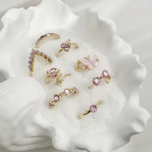 Vista macro detallada de varios anillos dorados con piedras rosas en una concha