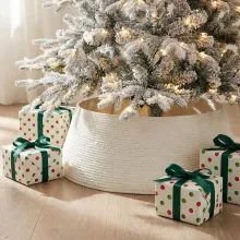 Close-up of a white woven Christmas tree collar base in a cozy festive setting