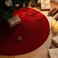 Detailed view of a deep red cable-knit Christmas tree skirt in a cozy home setting