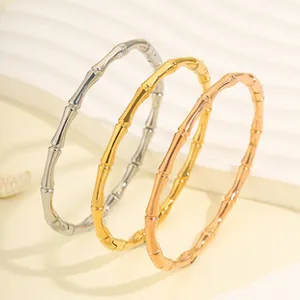 Primo piano di tre bracciali in acciaio inox a snodo di bambù in oro argento e rosa