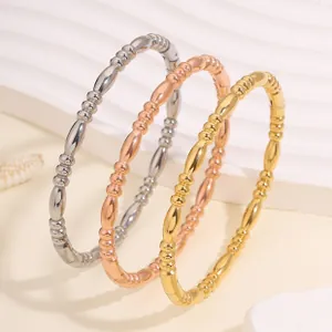 Vista dettagliata di tre bracciali in acciaio inossidabile stile bambù in oro e argento