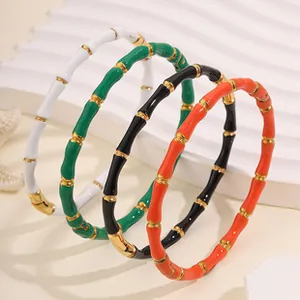 Vista macro dettagliata di quattro braccialetti colorati in acciaio inox stile bambù
