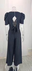 Detailed back view of a black puff sleeve wide leg jumpsuit featuring a stylish cutout and bow