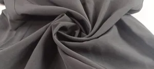 Close-up detail of smooth black woven fabric texture for a solid color jumpsuit