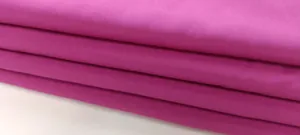 Vista macro della trama del tessuto fucsia magenta di alta qualità per tuta intera