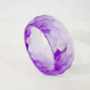 Nahaufnahme eines lila transparenten Harzarmreifens mit modernem geometrischem Schliff.