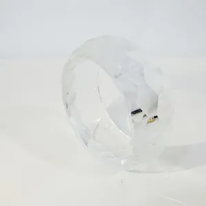 Nahaufnahme eines modernen facettierten Armreifs aus klarem Harz mit geometrischem Design