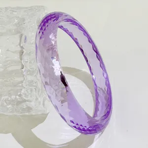Detailaufnahme eines lila transparenten Harzarmreifs mit facettiertem Gitterdesign