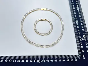 Close-up of gold stainless steel necklace and bracelet set with square zircons.