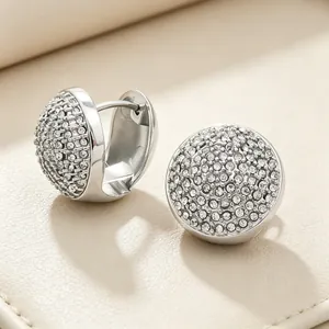 Gros plan de boucles d'oreilles ovales argentées serties de cristaux blancs brillants