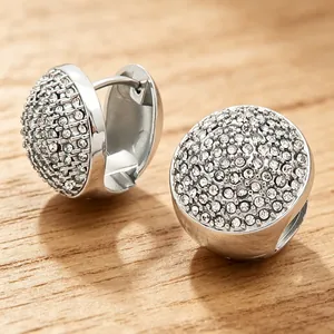 Détail de boucles d'oreilles créoles ovales en acier inoxydable avec cristaux brillants