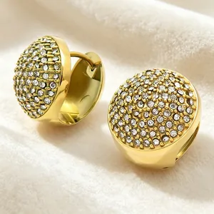 Vue macro détaillée de boucles d'oreilles ovales dorées avec pavage complet de strass