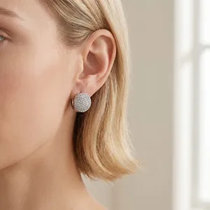 Gros plan détaillé de boucles d'oreilles ovales en acier inoxydable serties de cristaux.