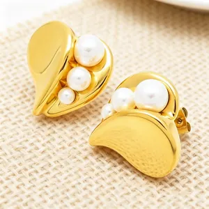 Detailed view of elegant French gold heart earrings featuring white pearl inlays