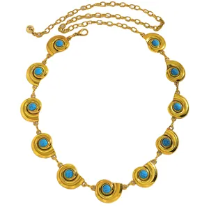 Gros plan sur une ceinture chaîne dorée vintage avec breloques en nacre turquoise
