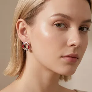 Elegant silver-toned geometric irregular earring with red enamel detail shown on model