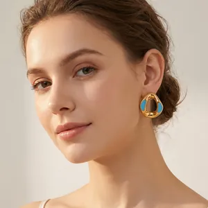 Close-up shot of a model wearing a luxury gold geometric earring with blue enamel