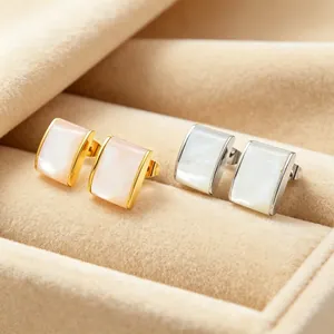 Detail view of golden and silver stainless steel quadrilateral shell stud earrings in a box