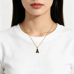 Elegante collar de acero inoxidable dorado con un colgante de inicial A en esmalte negro