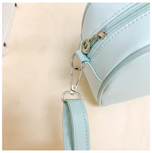 Vue macro d'un sac rond bleu clair avec ferrures argentées et coutures soignées