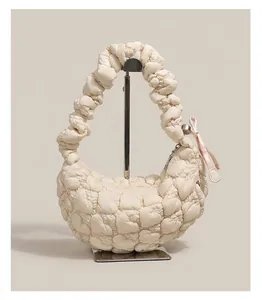 Close-up of cream quilted cloud bag with heart textures and pink silk ribbon detail