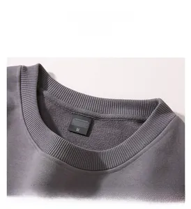Détail du col rond côtelé et de l'étiquette de taille sur un sweat-shirt gris foncé épais