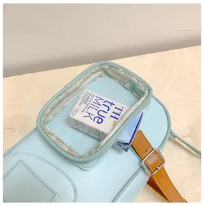 Détail du sac à bandoulière bleu clair avec poche avant transparente et boucle brune