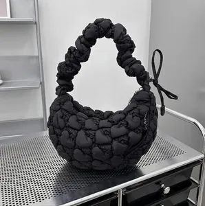 Detail of black cloud bag featuring heart-shaped bubble texture and ribbon bow on metal rack