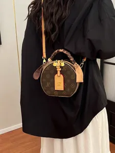 Runde Vintage-Umhängetasche mit Monogramm-Muster und dekorativem Seidenschal