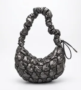 Detailed view of the metallic gray quilted cloud bag with puffy ruffles on a black rack