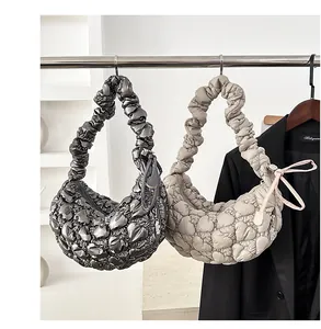 Close-up of quilted bubble hobo bags in grey and beige with ruched handle details