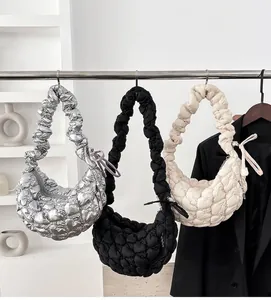 Detailed view of quilted cloud crescent bags in silver, black and beige on hangers