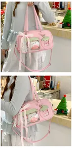 Détail du sac ita rose avec fenêtre fraise, nœud en dentelle et peluche exposée