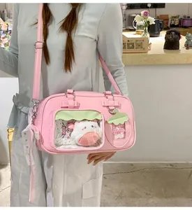 Détail d'un sac ita rose avec fenêtre montrant un chat peluche et boucle cœur