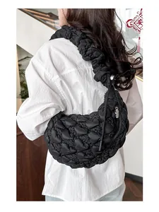 Detail of black cloud pleated shoulder bag featuring heart quilting and a bear charm