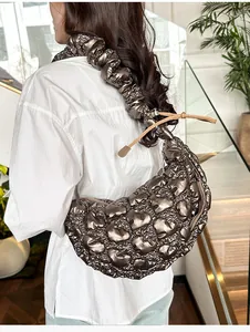 Detail of metallic brown cloud bag featuring heart-shaped quilting and a ruched strap