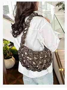 Detailed view of bronze ruched cloud bag showing metallic quilted texture and shoulder strap